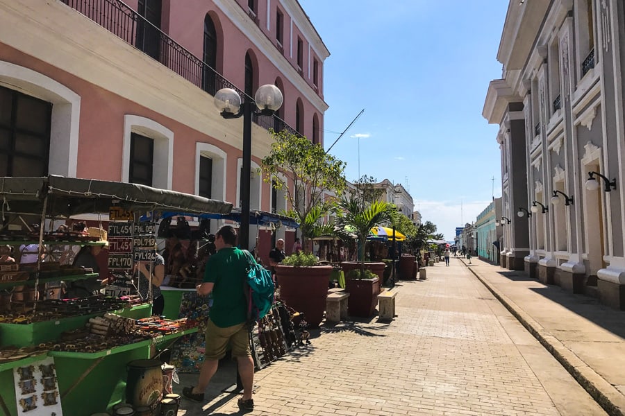 Cuba in 2 weeks: A man stands at a market stall on a street in Cienfuegos.