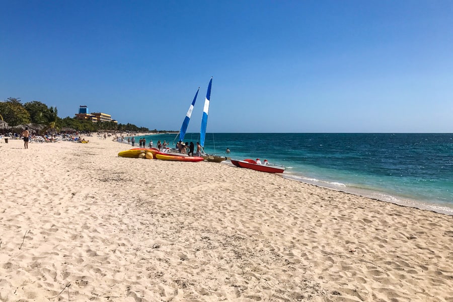 Planning a trip to Cuba: Sandy beach with kayaks and beachgoers.