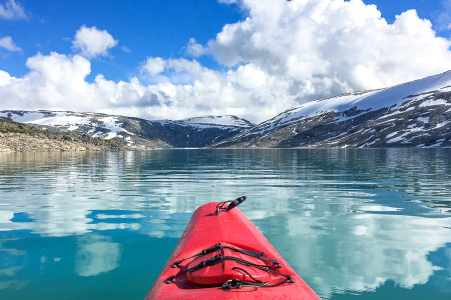 A red kayak paddles Styggevatnet glacier lake towards Austdalsbreen glacier on day 9 of our Norway road trip itinerary.