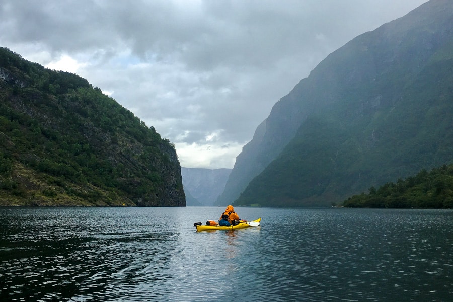 A lone kayaker paddles Nærøyfjord, one of the most beautiful fjords in Norway.
