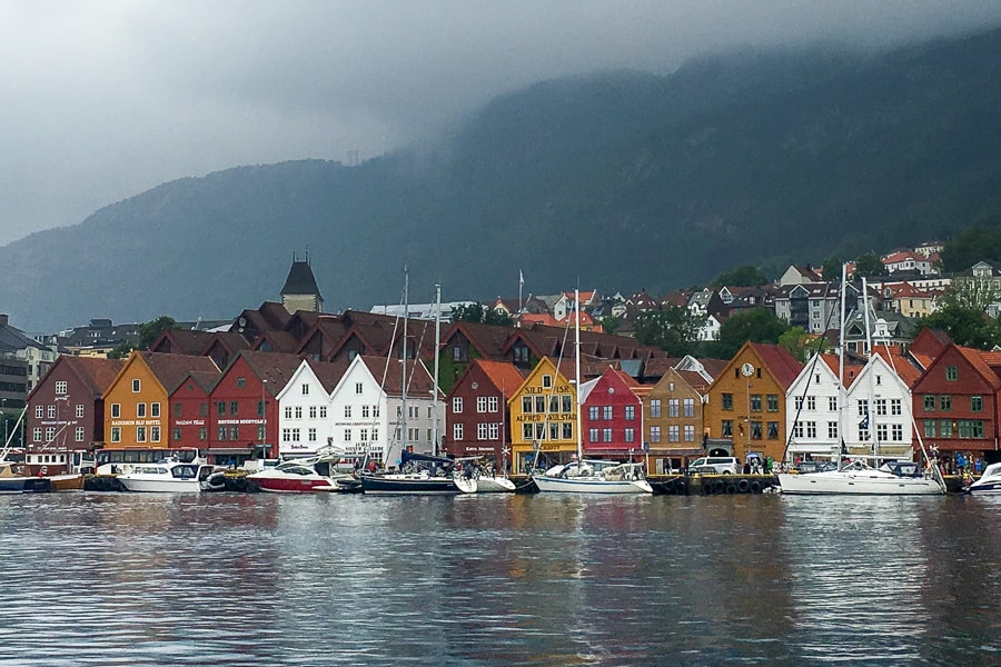 Views across the rain swept harbour to the old wooden factory buildings of historic Bryggen Wharf.