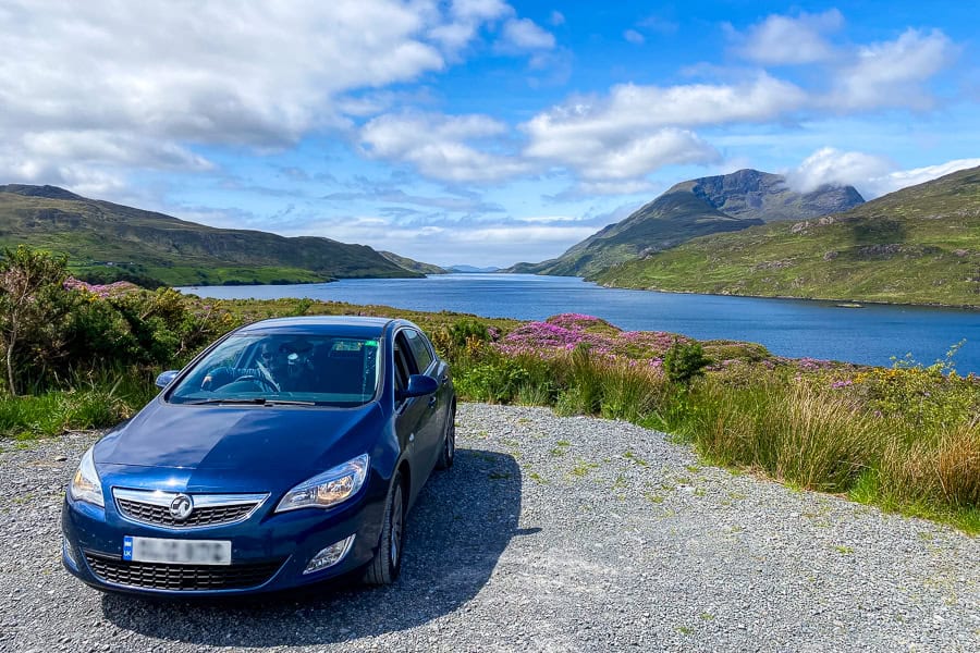 A blue car parked at a viewpoint overlooking Killary Fjord in County Mayo during our self-drive Ireland tour.