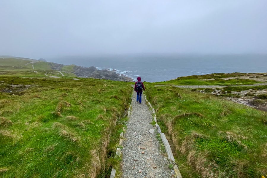 A hiker takes on the beautiful, rainswept walking trail at Malin Head.