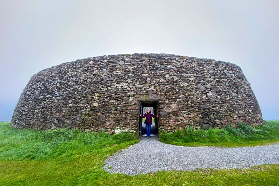 The well-preserved walls of Grianan of Aileach shrouded in mist, with a person standing in the doorway.