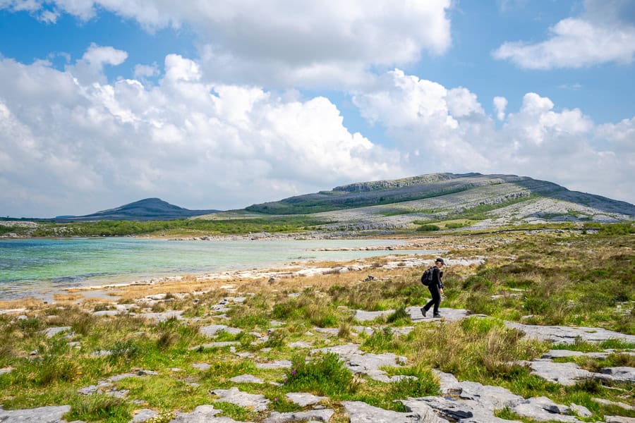The otherworldly glacio-karst terraces of the Burren rise behind Lough Gaelan on the Mullaghmore Loop Hike.