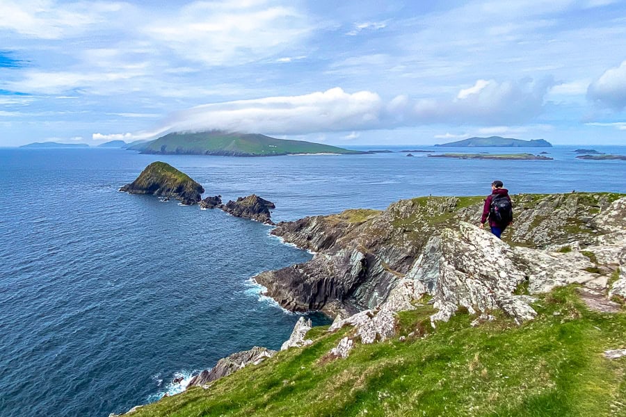 A hiker enjoys the stunning, rocky view towards the Blasket Islands from Dunmore Head – a highlight of our Ireland itinerary.
