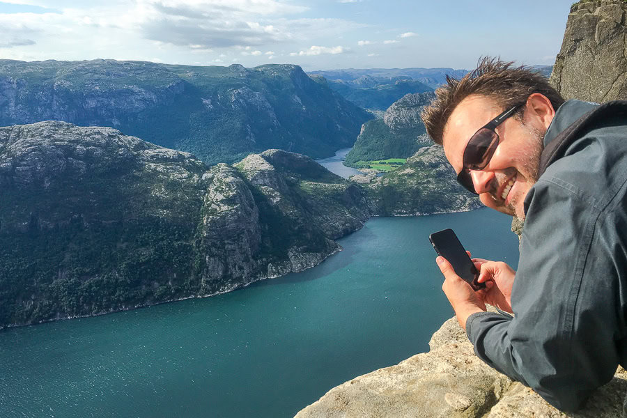 A visitor peeks over the edge of Pulpit Rock – a highlight of hiking in Norway.