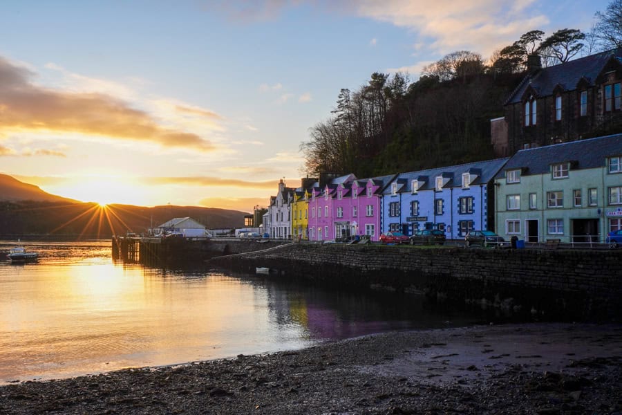 A row of colourful houses next to a body of water.