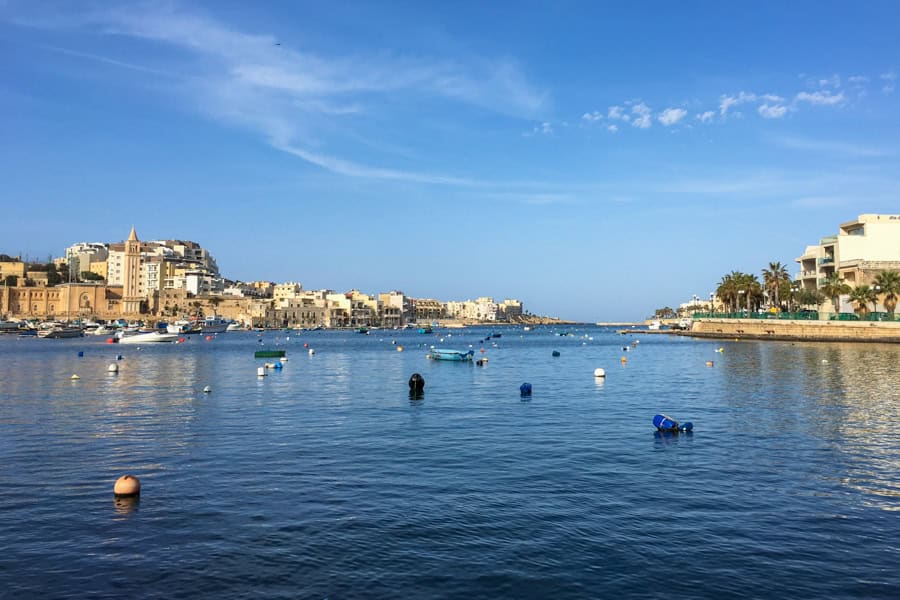 Malta sightseeing: a body of water with boats and buildings in the background.