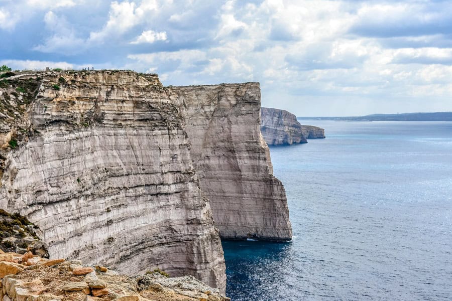 High white cliffs rise above a blue sea.