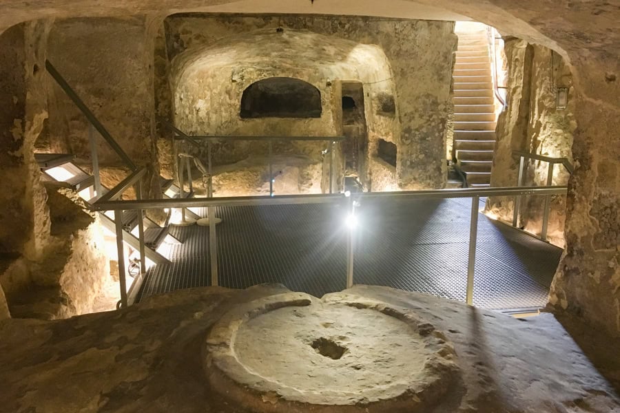 A lit-up room carved out of the stone with stairs at St Paul’s Catacombs, one of the stranger places to go in Malta.