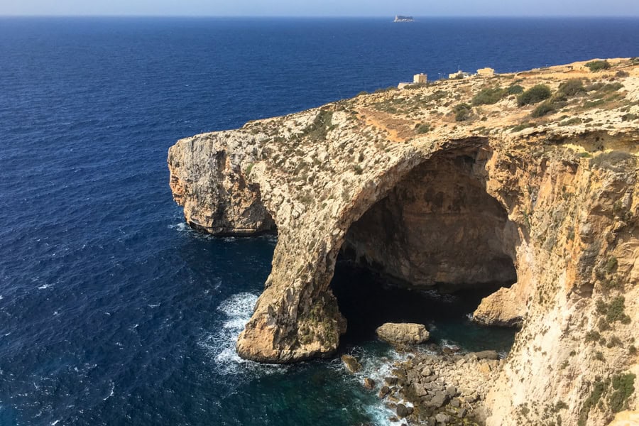 A huge rock arch cuts through the cliff at Blue Grotto, one of the most beautiful places in Malta.