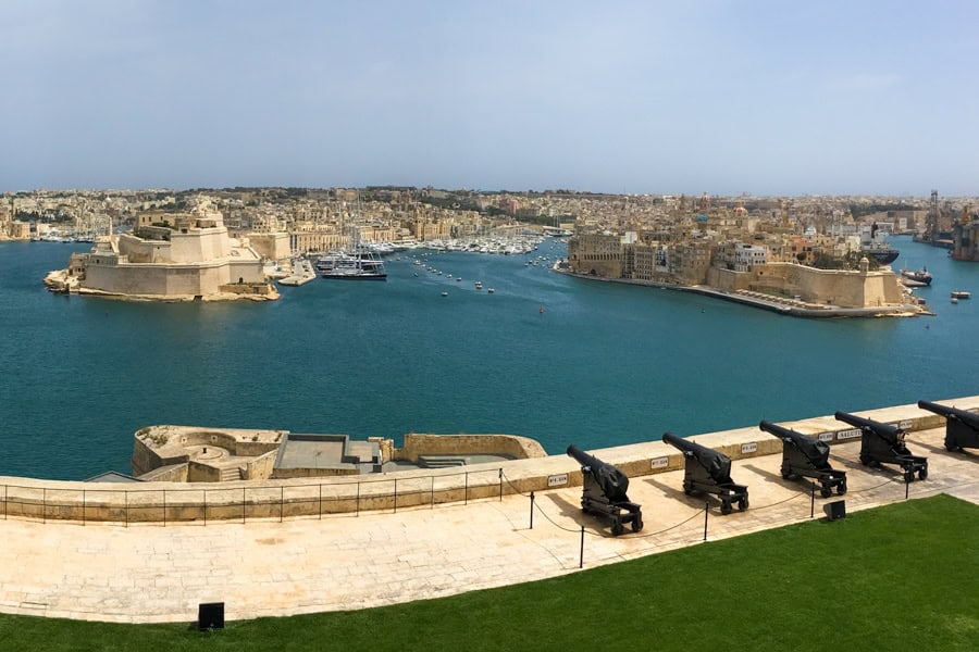 View across the water to the Three Cities with cannons in the foreground.