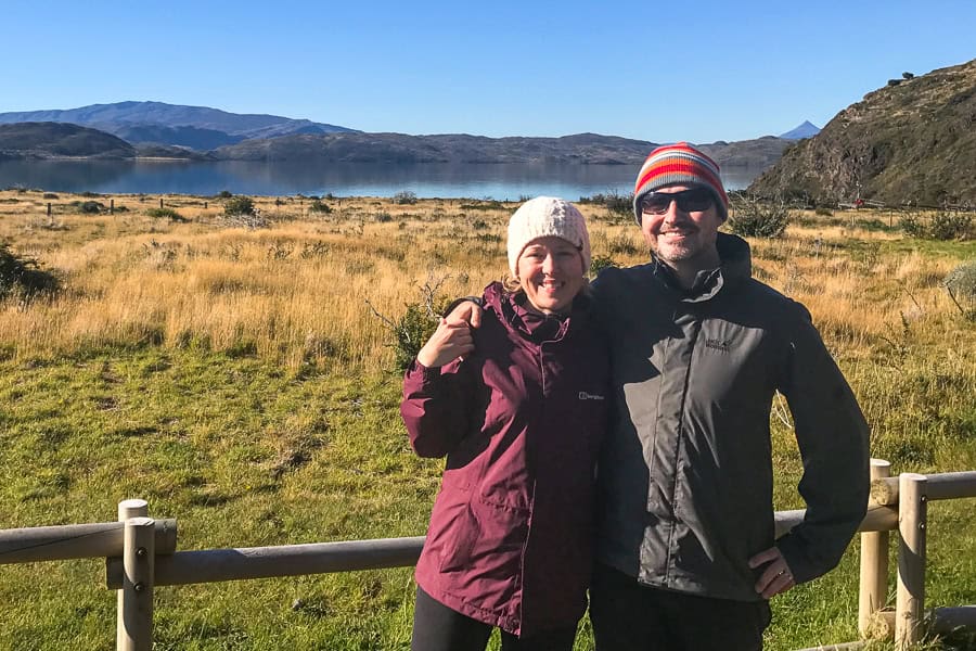 Two people in front of a lake at Paine Grande after hiking the W .