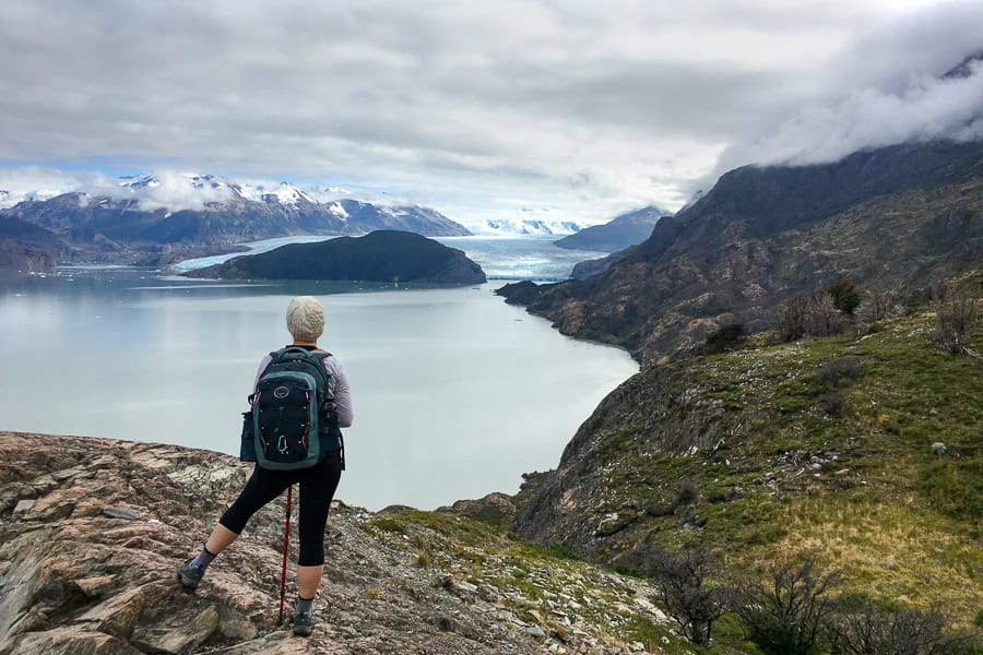A person looks out lake towards a glacier on the W Trek in Torres del Paine.