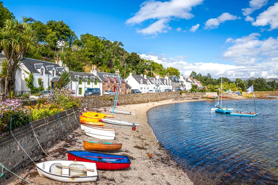 Whitewashed houses of Plockton bay dotted with colourful rowboats on our diversion from the classic North Coast 500 route.