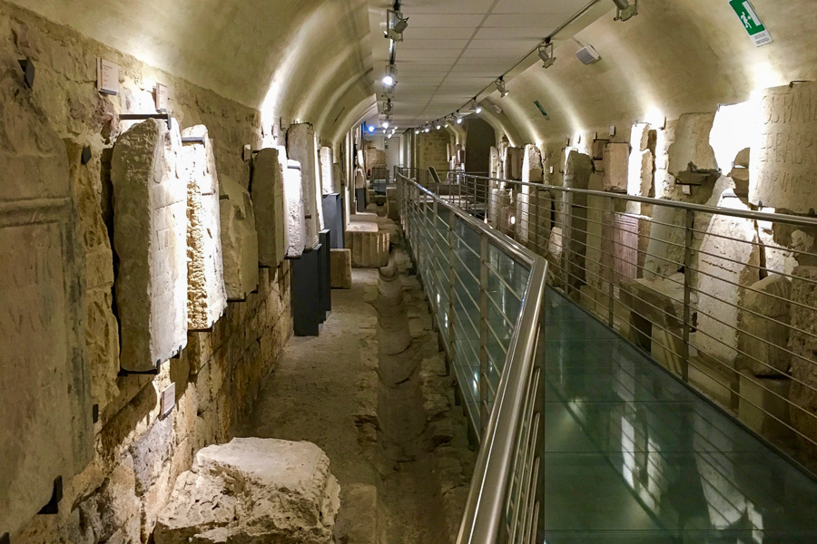 A subterranean exhibition space displaying the remains of the Roman Forum of Asisium, a highlight of our Central Italy itinerary.
