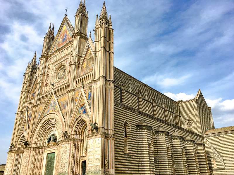The ornate reliefs on the façade of the Duomo di Orvieto are a highlight as you road trip Tuscany and central Italy.