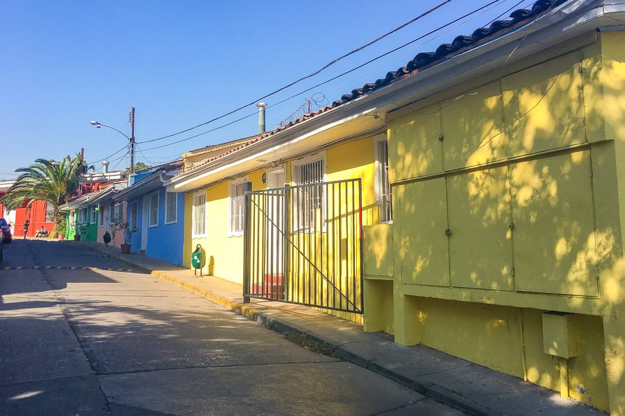 A street of multicoloured houses in Santiago’s Bellavista neighbourhood on a sunny day with blue skies.