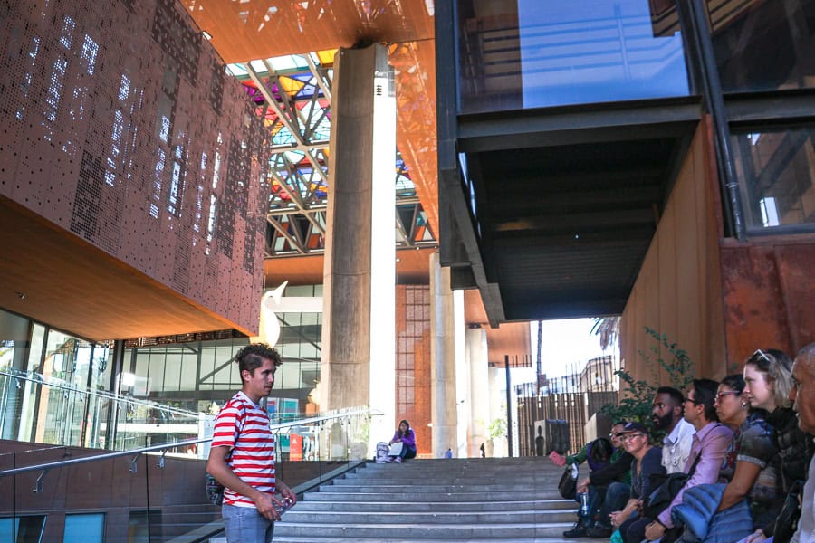 A guide talks to a walking tour group outside the GAM Cultural Centre during a Santiago highlights walking tour