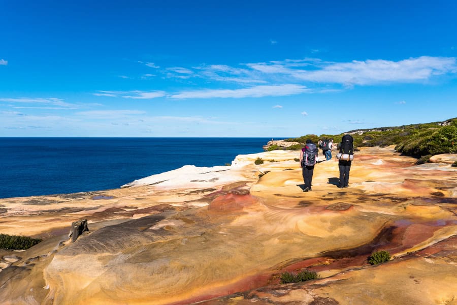 Colourful sandstone offsets blue ocean and sky on the Royal National Park Coast Track in the Royal National Park in Sydney.