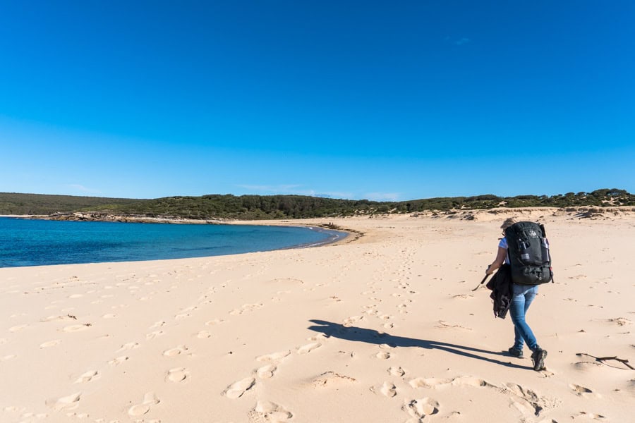 A hiker crosses the sand at Marley Beach on the Royal National Park Coast Track.