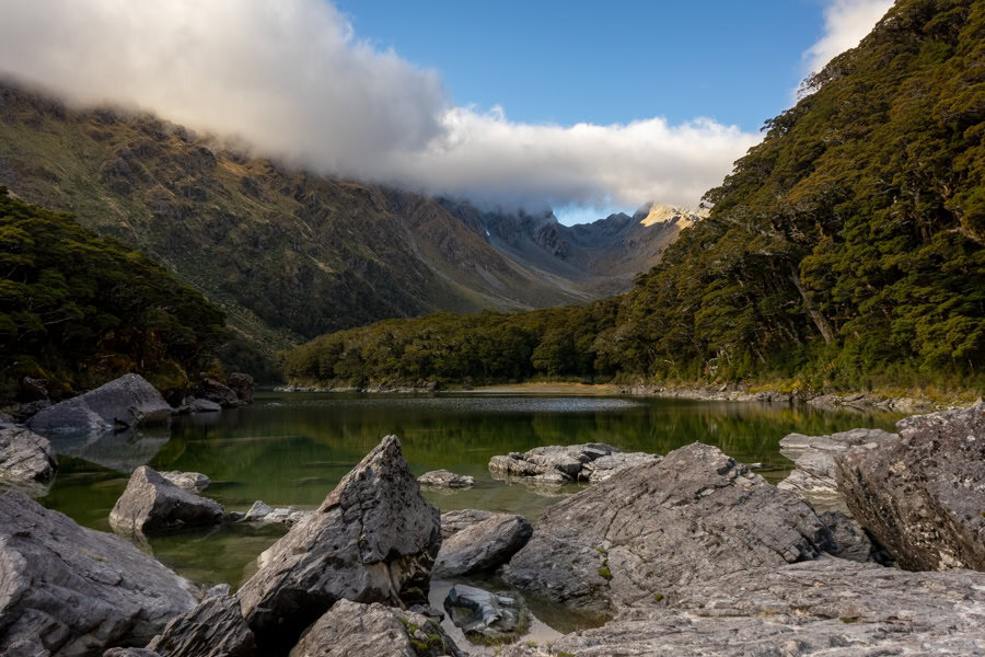 Boulders scatter the water's edge at Lake Mackenzie and mountains rise in the background.
