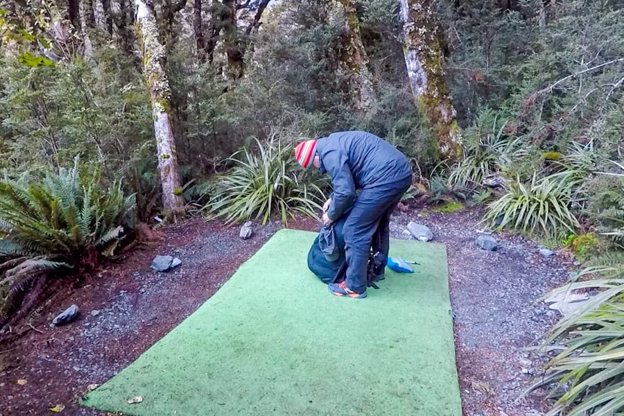 A person stands in a campsite at the Lake Mackenzie hut and campsite.