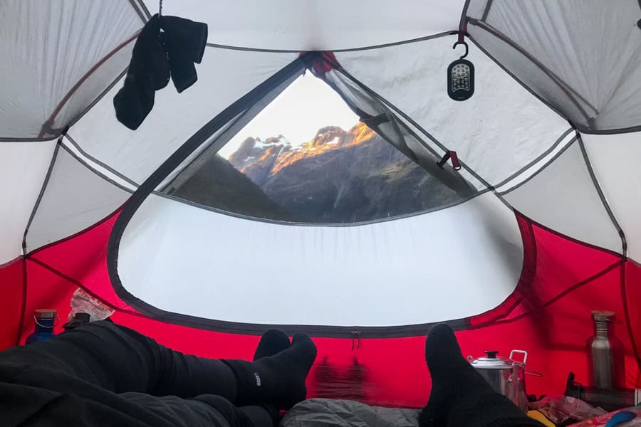 View of mountains from inside a tent while trekking in New Zealand.