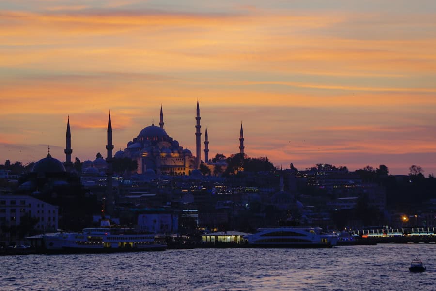The Istanbul skyline with spires, a dome and water in the foreground.