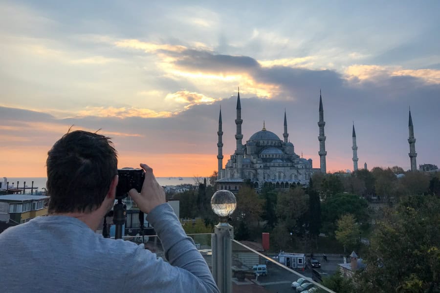 A person taking a photo of the Blue Mosque from a rooftop, one of the best things to do in Istanbul.
