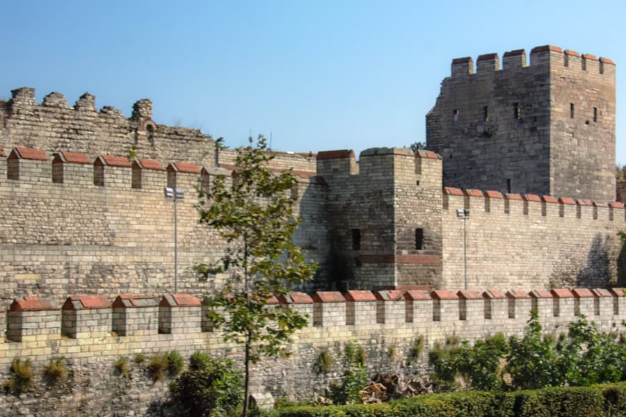 Stone walls with parapet and a tower.