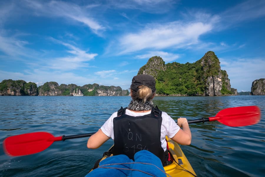 Person kayaking on a calm body of water – one half of a couple travelling together in Vietnam.