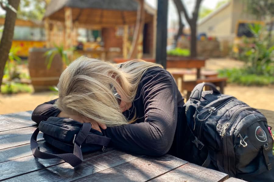 A person asleep with their head on a table during a trip – the kind of tired moment that comes with on-the-go travel as a couple.