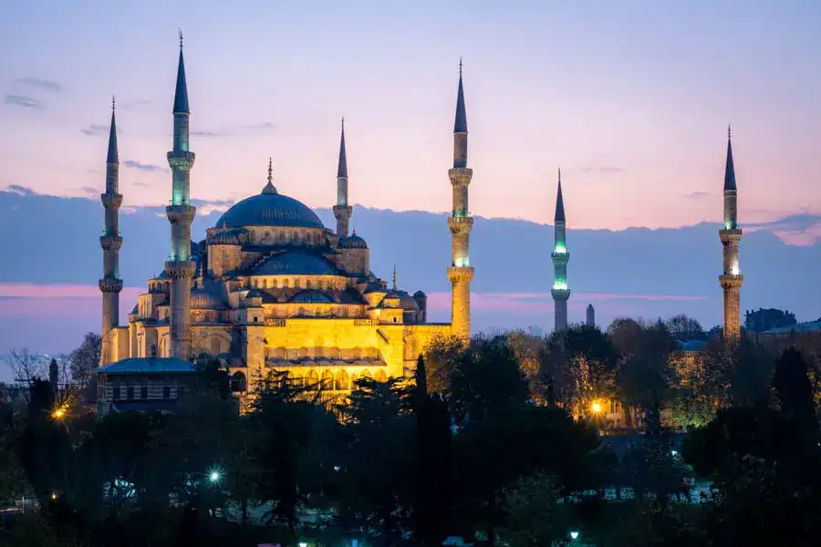 The lit-up towers and domes of the Blue Mosque at twilight, one of the top things to see in Istanbul.