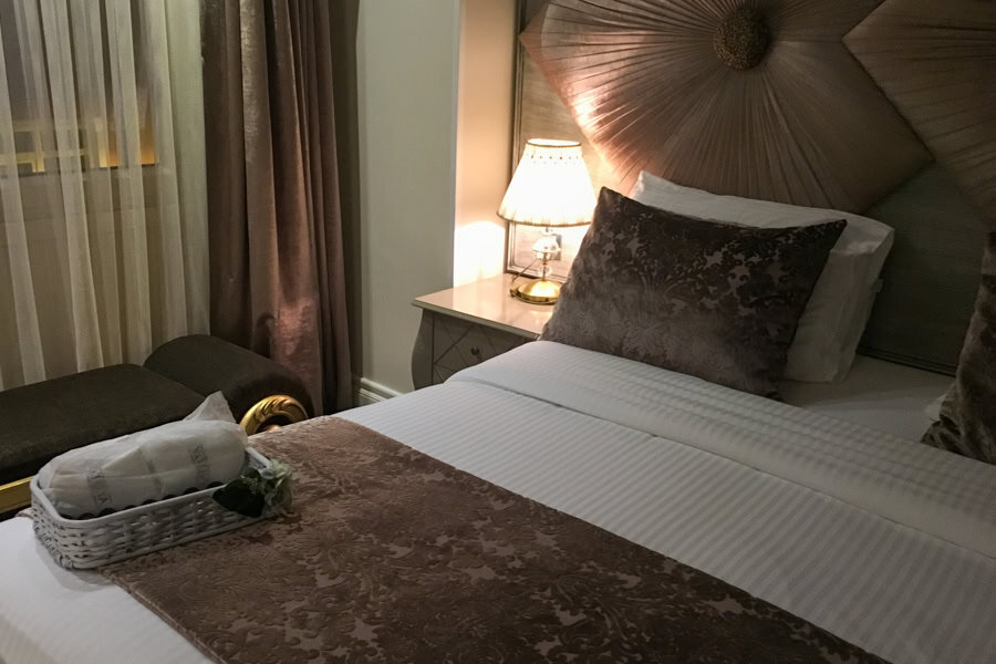 A bed with pillow and side table in an Istanbul accommodation.