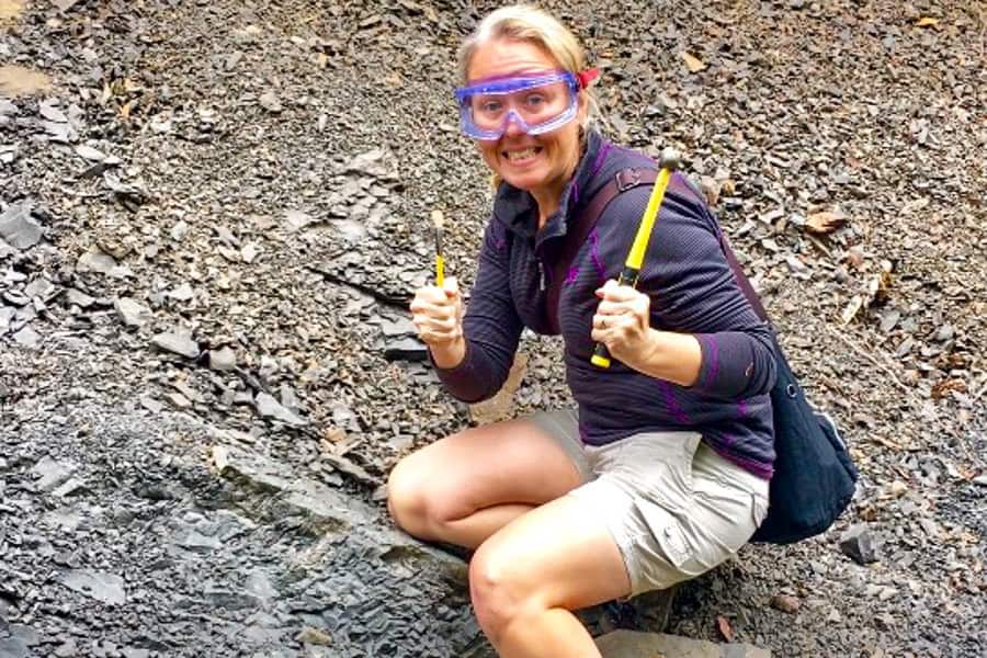 A tourist armed with hammer, chisel and a protective mask searches for fossils on a tour from Courtenay.