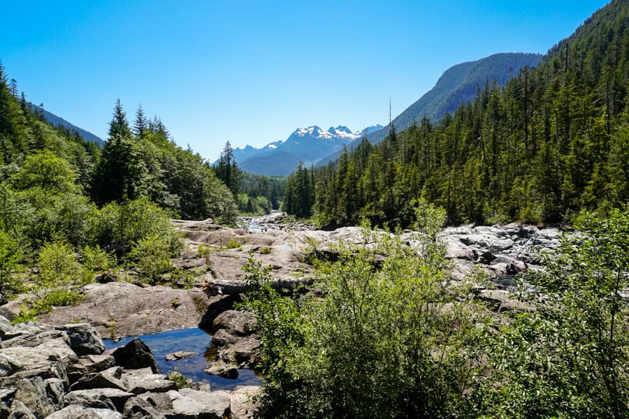 River and mountain views across a peaceful valley on the road to Tofino on day 5 of our Vancouver Island itinerary.