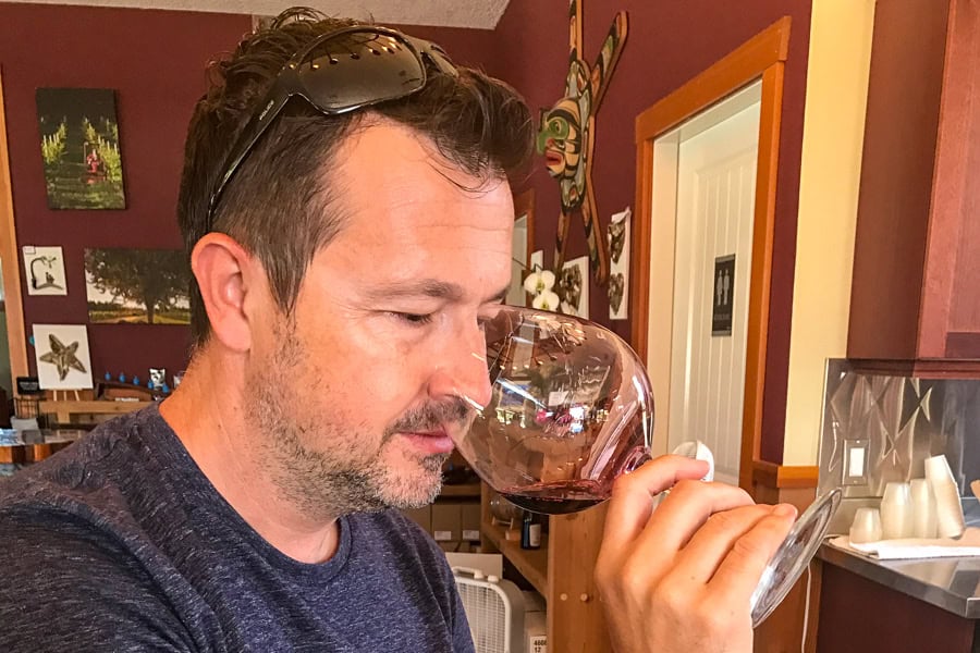 A customer takes a sniff of a red wine during a tasting on a Vancouver Island wine tour.