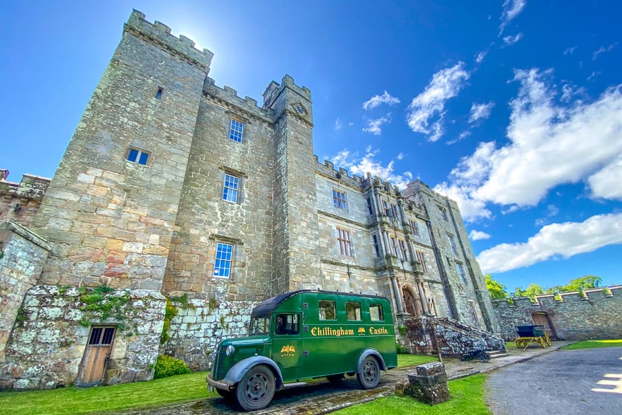 The high walls of Chillingham Castle with a green van outside – for us one of the quirkier places to visit in Northumberland.