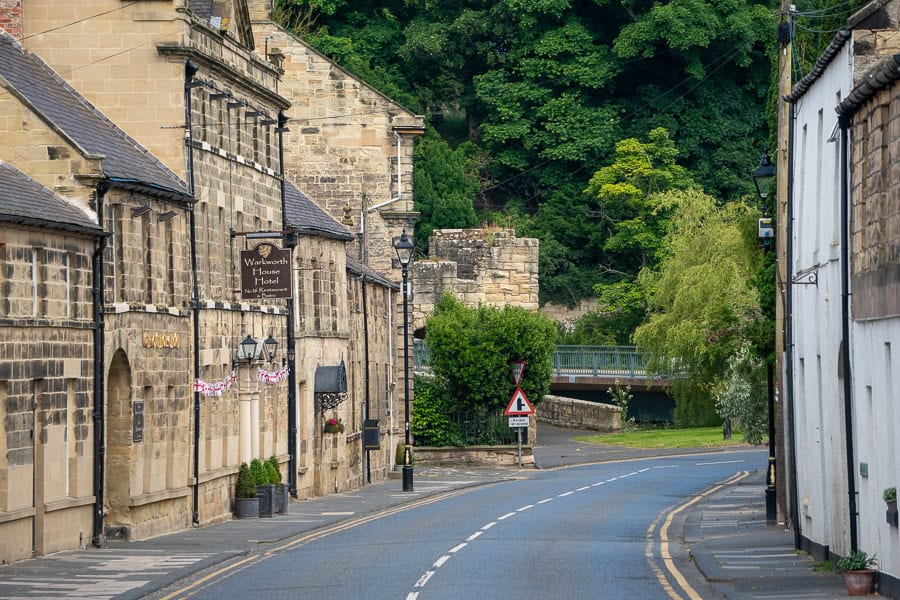 Sandstone buildings line the main road through historic Warkworth, just one of the great stops on a Northumberland road trip.
