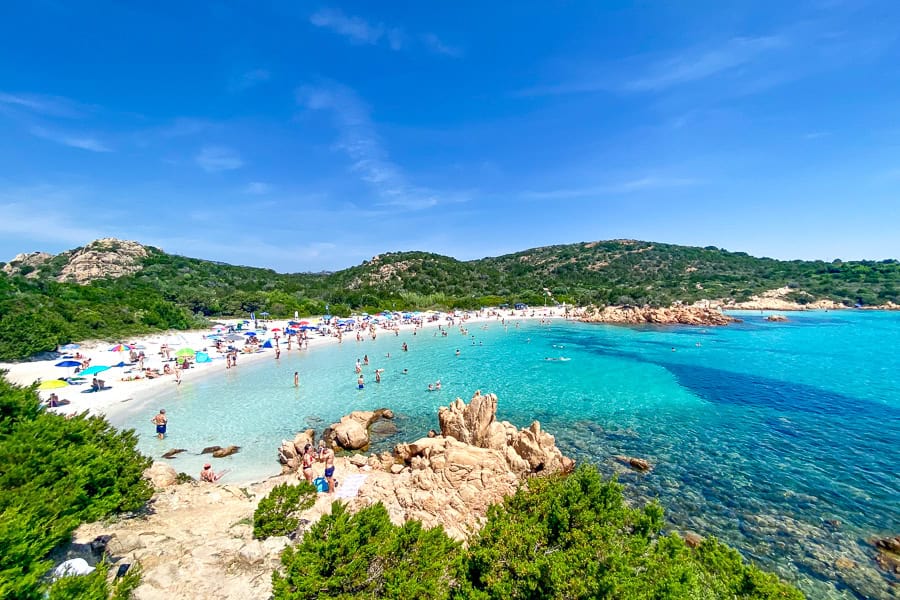 A crescent of white sand bustling with beachgoers at Spiaggia del Principe beach on the Costa Smeralda.
