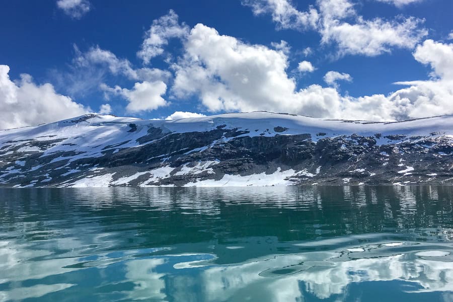 Views of snowcapped mountains surrounding Styggevatnet – glacier kayaking in Norway commences when glacier lakes thaw.