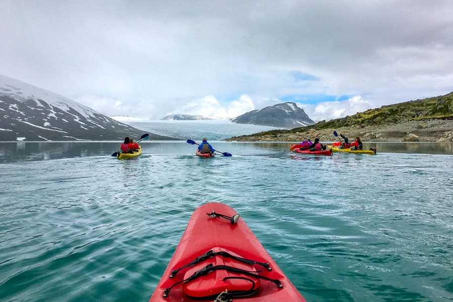 A glacier kayaking group on Styggevatnet heading towards the huge ice terminus of Austdalsbreen shrouded in cloud.