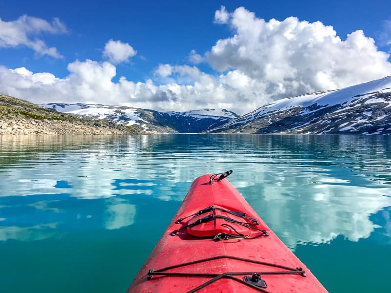 View from a kayak across a turquoise lake to Austdalsbreen glacier terminus and the start of our glacier hike in Norway.